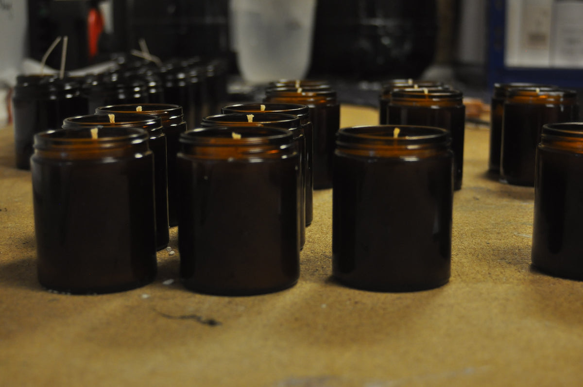 Rows of amber jars on the workbench, wicks set, waiting to be poured