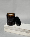 English gentlemen soy candle by house of two trees, amber glass jar with a black lid and a cream label
