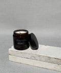 Sharp peels candle with the lid off, showing the cotton wick and natural soy wax