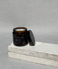 Calm candle with the lid off, showing the cotton wick and natural soy wax